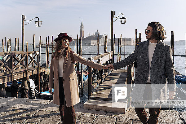 Junges Paar geht Hand in Hand an der Uferpromenade von Venedig  Italien