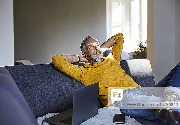 Mature man relaxing on couch at home