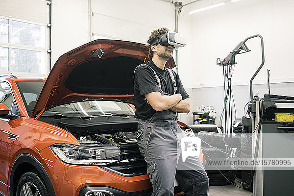 Automechaniker mit VR-Brille in einer Werkstatt