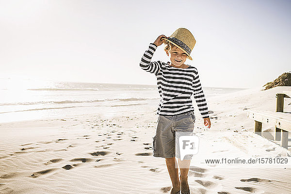 Portrait of smiling boy with hat on the beach