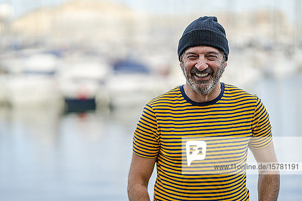 Porträt eines lachenden  reifen Mannes mit Mütze und gestreiftem T-Shirt  Alicante  Spanien