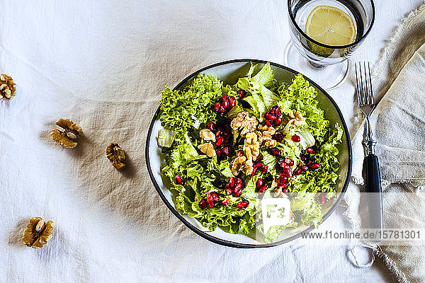 Schale mit grünem Salat mit Walnüssen und Granatapfelkernen