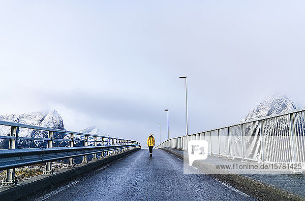 Tourist überquert eine Brücke bei Hamnoy  Lofoten  Norwegen