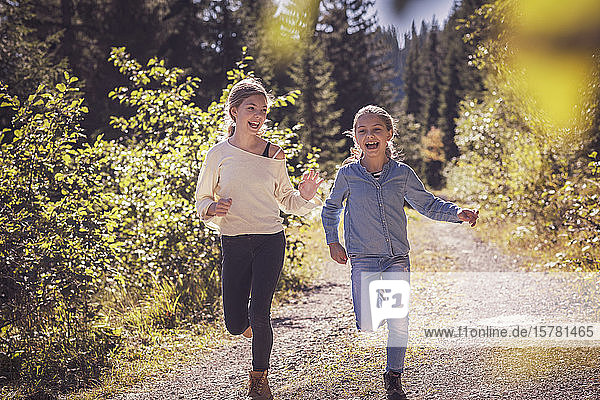Mädchen laufen und vergnügen sich auf einem Waldweg auf dem Land