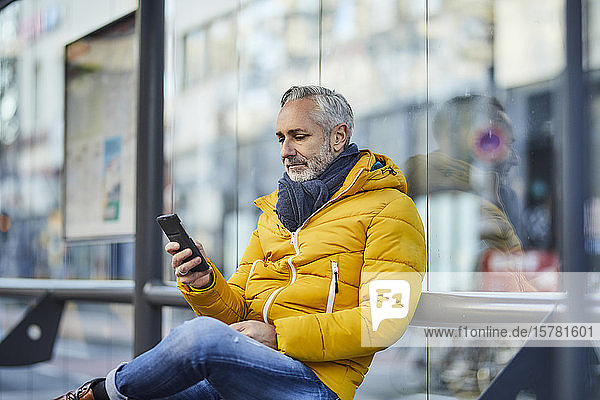 Erwachsener Mann benutzt Handy in der Stadt