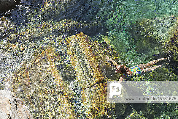 Woman swimming in refreshing Verszasca river