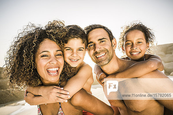 Porträt einer glücklichen Familie  die sich am Strand amüsiert