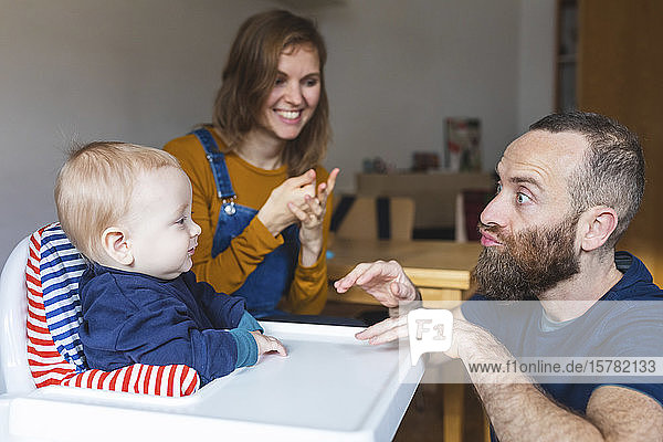 Father and mother playing with their son at home