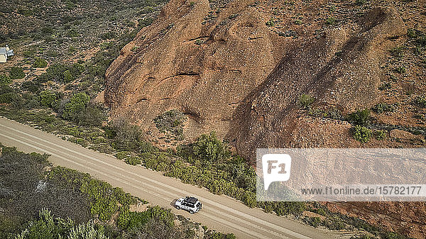 Südafrika  Western Cape  Swellendam  Luftaufnahme eines 4x4-Autos  das auf einer alpinen Schotterstraße fährt