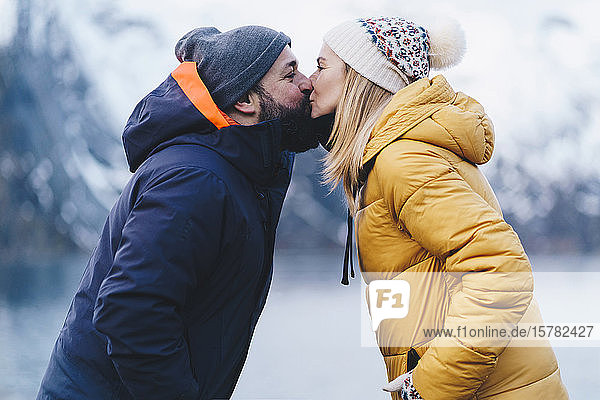 Tourist couple kissing at Hamnoy  Lofoten  Norway