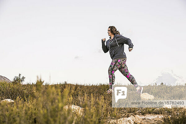 Plus-Size-Model jogging in the countryside at sunset