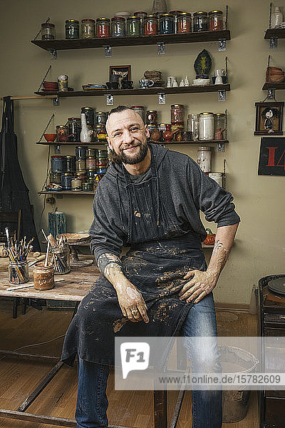Portrait of a confident potter in workshop