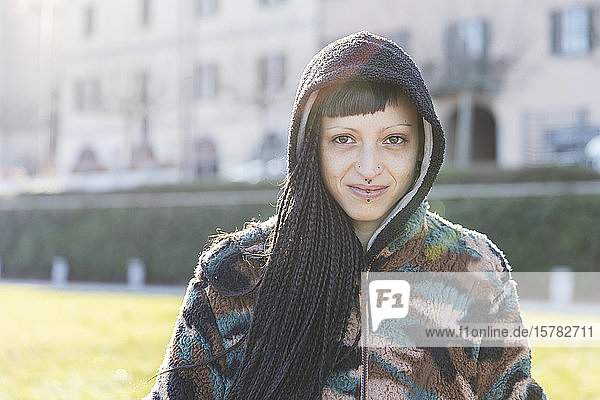 Portrait of smiling young woman with piercings and braids  Como  Italy