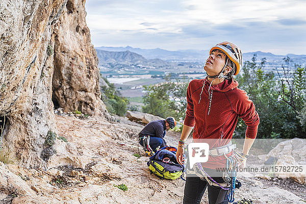 Female climber preparing looking up rock face