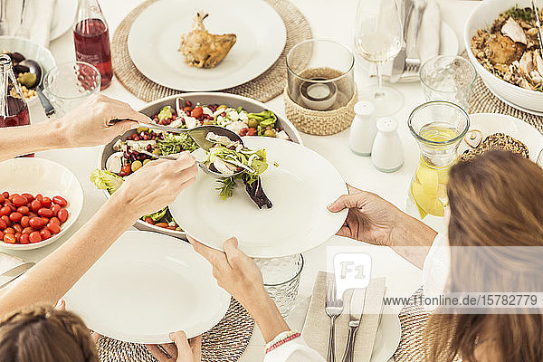 Nahaufnahme von Familie und Freunden beim gemeinsamen Mittagessen mit Salat