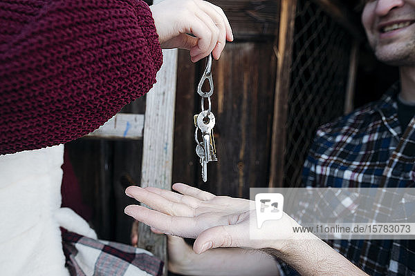 Nahaufnahme der Hand des Mädchens bei der Schlüsselübergabe an ihren Vater