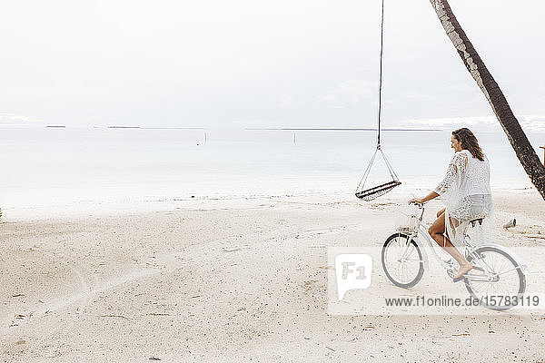 Woman riding bicycle on the beach  Maguhdhuvaa Island  Gaafu Dhaalu Atoll  Maldives