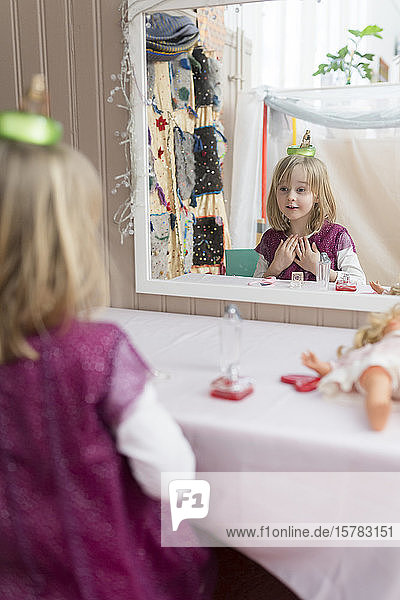 Kleines Mädchen beobachtet beim Spielen ihr Spiegelbild