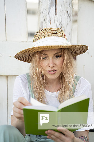 Junge Frau verbringt einen Tag am Meer liest ein Buch am Strand