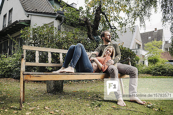 Couple relaxing on bench  enjoying nature in their garden
