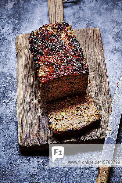 Hausgemachter Hackbraten mit Erbsen italienischen Kräutern getrockneten Tomaten und Ketchupglasur