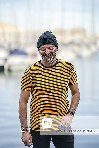 Portrait of laughing mature man wearing cap and striped t-shirt  Alicante  Spain