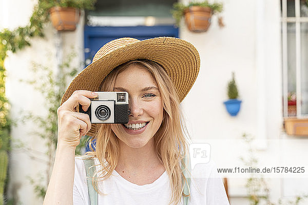 Portrait of happy young woman with camera