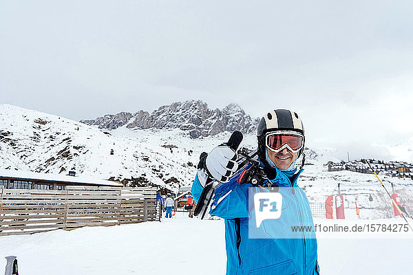 Portait of smiling man with skis in ski area