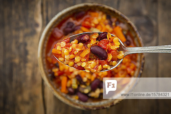 Löffel veganer Chili mit roten Linsen Stangensellerie Kidneybohnen Tomaten und Karotten