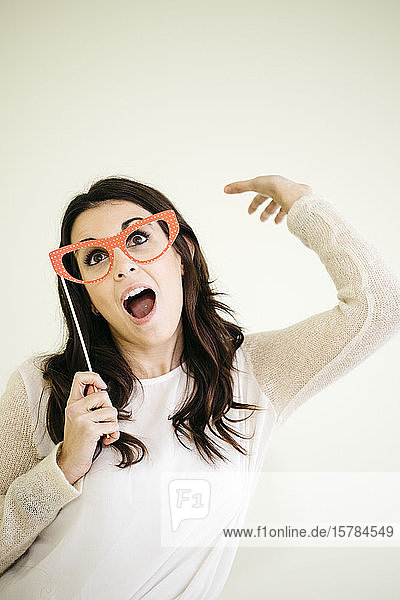 Porträt einer verspielten jungen Frau mit Komödienbrille