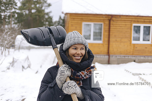 Portrait of smiling woman with snow shovel