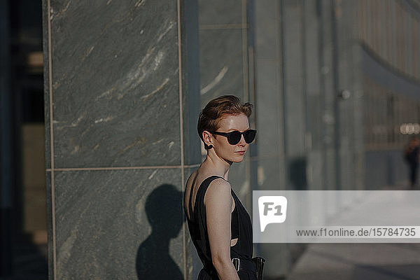 Elegant red-haired woman with sunglasses in the city  portrait