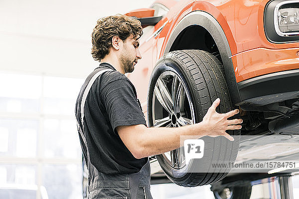Automechaniker in einer Werkstatt beim Reifenwechsel