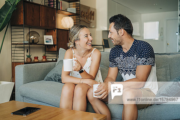 Happy relaxed couple sitting on couch in living room