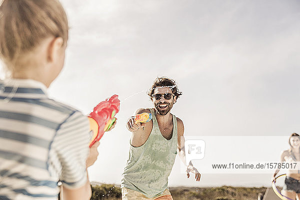 Father and daughter having a water fight