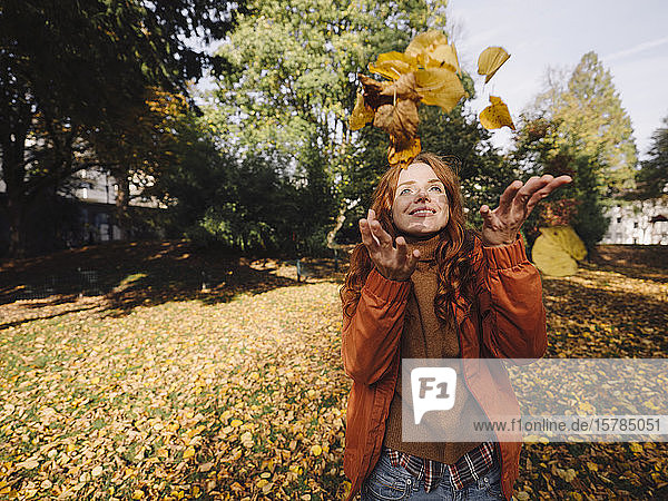Happy redheaded woman enjoying autumn in a park