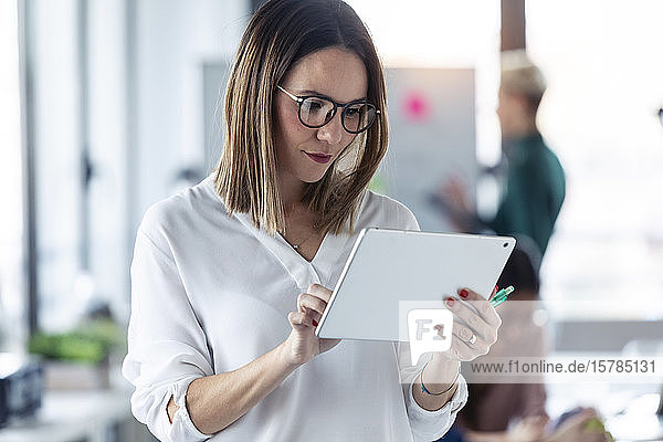 Unternehmerin benutzt digitales Tablett im Büro