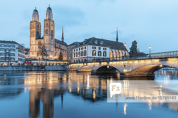 Schweiz  Zürich  Grossmünsterkirche und Munsterbrucke über der Limmat in der Abenddämmerung