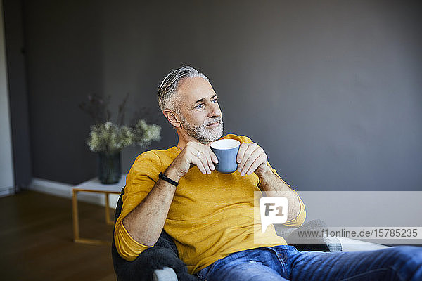 Relaxed mature man at home with cup of coffee