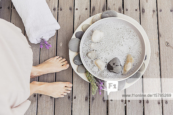 Close-up of woman's feet next to bowl with water
