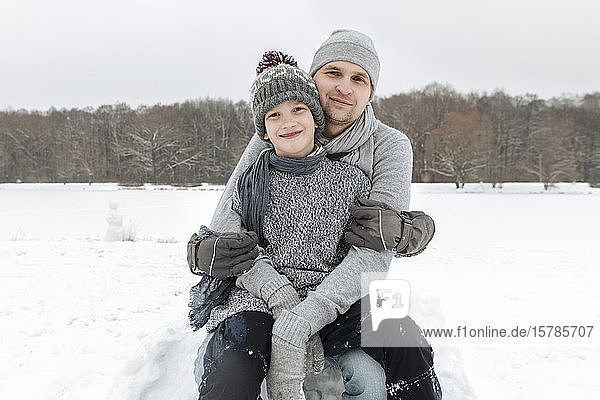 Porträt eines glücklichen Vaters mit diesem Sohn in Winterlandschaft