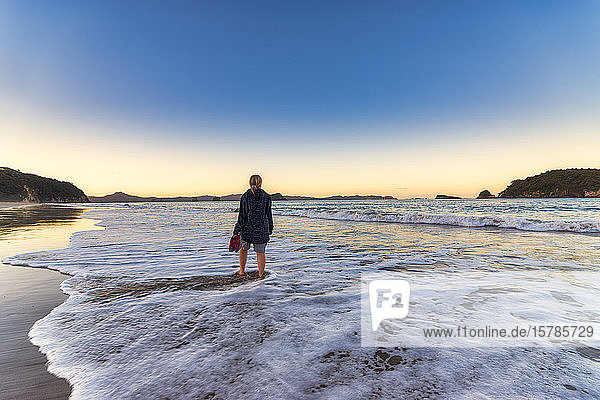 Frau am Strand von Hahei Beach bei Sonnenaufgang  Waikato  Nordinsel  Neuseeland