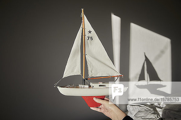 Hand holding model sailboat