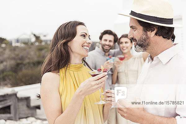 Ehepaar und Freunde treffen sich auf einer Cocktailparty