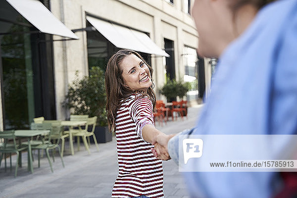 Glückliche Frau Hand in Hand mit dem Mann in der Stadt