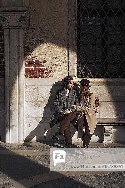 Junges Paar sitzt auf einer Bank in Venedig  Italien