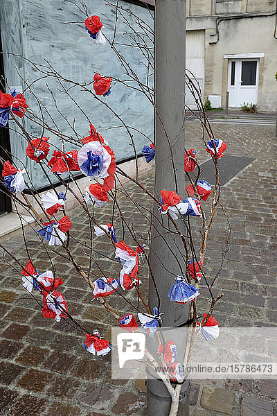 Frankreich  Normandie  Dekoration für den Feiertag D-Day (6. Juni 1944 als Beginn der alliierten Landung in der Normandie im Zweiten Weltkrieg) - rote  weiße  blaue Blumen aus Papier