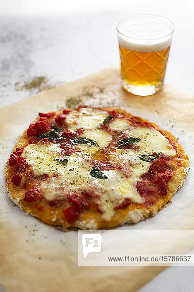 Glas Bier und verzehrfertige hausgemachte Pizza Margharita
