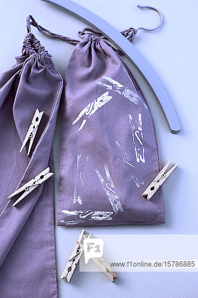 Deutschland  Studioaufnahme einer lila Stofftasche mit Wäscheklammern