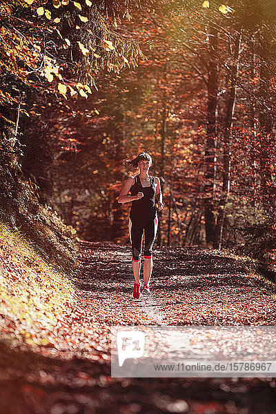 Frau joggt im Herbstwald